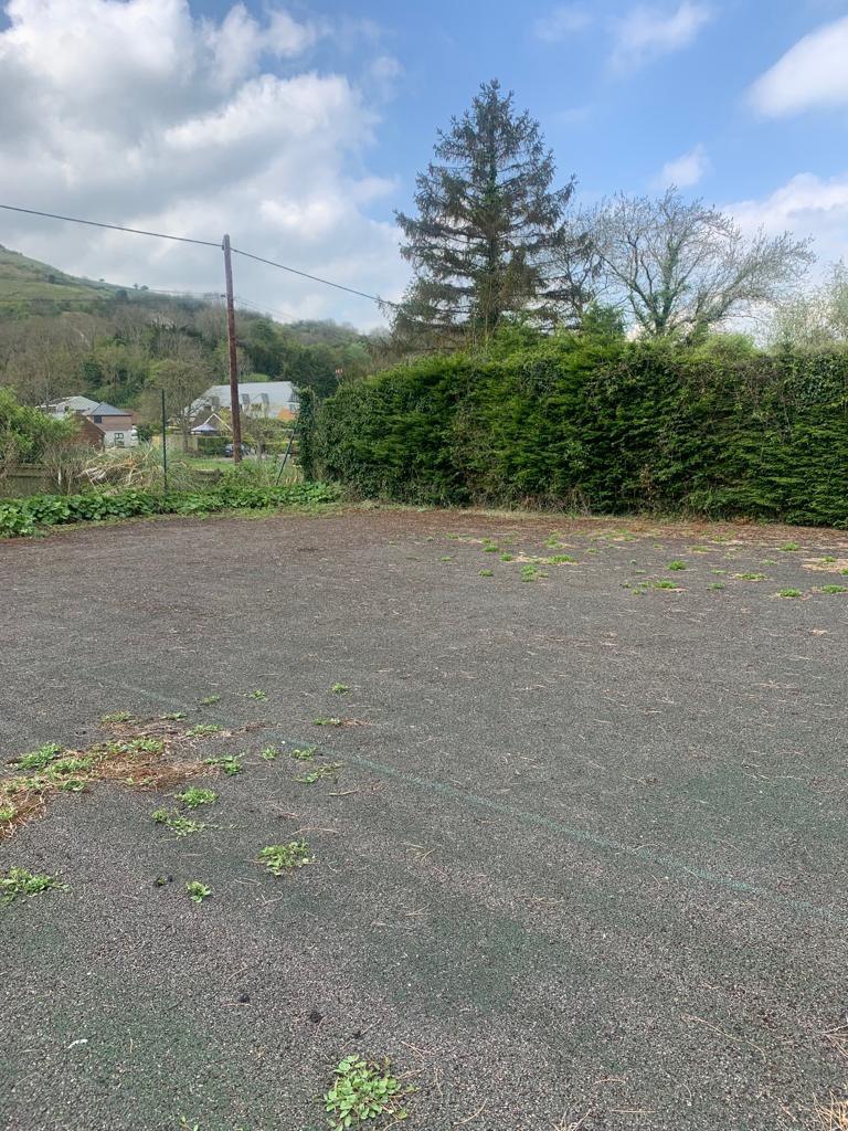 This is a photo of a tennis court in Surrey that is in need of refurbishment